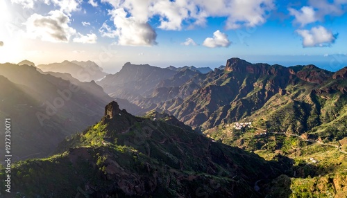 A scenic mountain range with lush greenery under a vibrant blue sky and white clouds
