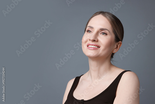 Portrait of beautiful woman on grey background, space for text