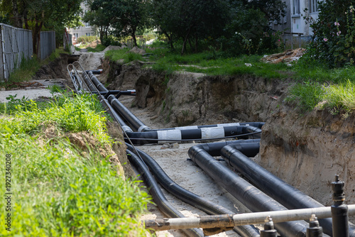 Foto Repair of underground water supply pipelines for apartment buildings in urban residential area with open trench and new plastic pipes