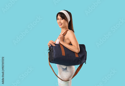 Young woman with sports bag...