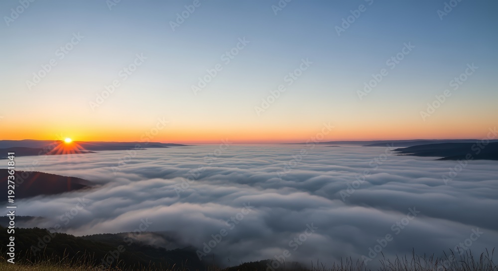 Fototapeta premium Radiant sunrise with a brilliant sunburst over a vast, calm sea of clouds filling a mountain basin.
