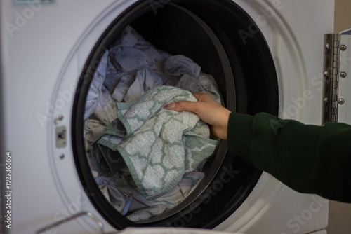 Wallpaper Mural Female hand loading towel into washing machine close up Torontodigital.ca
