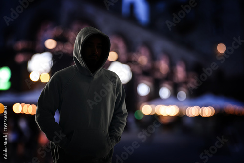 Foto Criminal in hooded sweatshirt in city at night