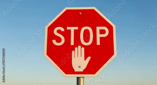 Red Stop Sign with Hand Symbol Against Blue Sky