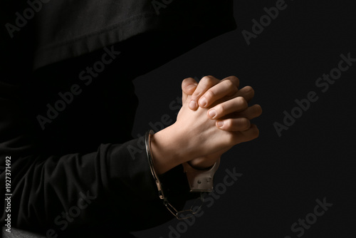 Young woman in handcuffs on...