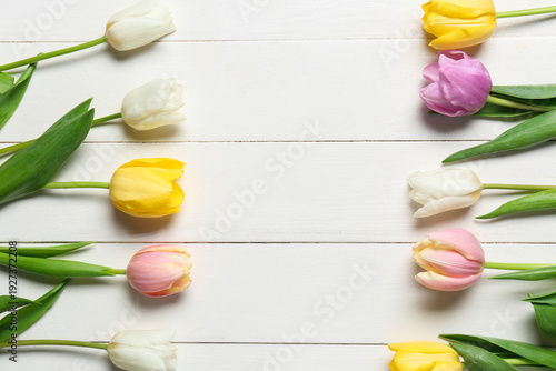 Beautiful tulip flowers on white wooden background