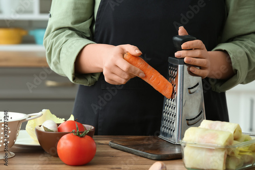 Woman grating carrot for st...