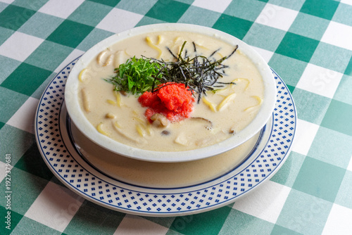 明太子、大葉、刻み海苔を添え、クリーミーな和風ホワイトソースにパスタを合わせた一皿。明太子のつぶつぶ感と薬味のアクセント、和洋折衷の優しい味わいを伝えるランチやディナーメニューの販促・広告用素材に。 | A Mentaiko (cod roe) and white sauce pasta topped with Shiso leaves and shredded Nori seaweed.