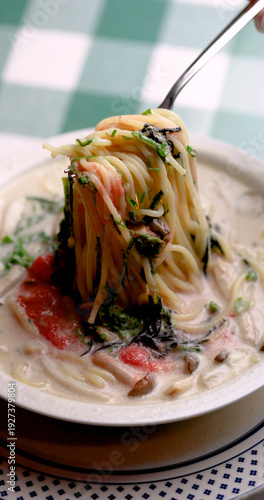 明太子、大葉、刻み海苔を添え、クリーミーな和風ホワイトソースにパスタを合わせた一皿。明太子のつぶつぶ感と薬味のアクセント、和洋折衷の優しい味わいを伝えるランチやディナーメニューの販促・広告用素材に。 | A Mentaiko (cod roe) and white sauce pasta topped with Shiso leaves and shredded Nori seaweed.