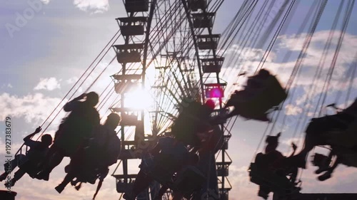 Traditional Bavarian folk festival Oktoberfest in Munich with famous rides Wellenflug swing carousel and Willenborgs Riesenrad Ferris wheel. Family fun and German culture at the Theresienwiese