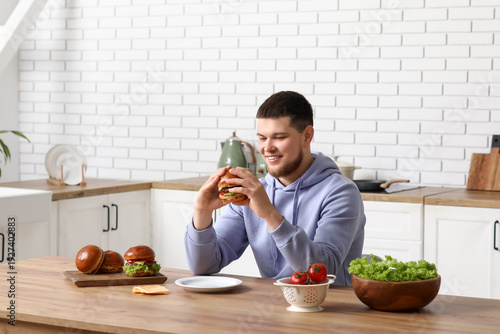 Young man with tasty burger...