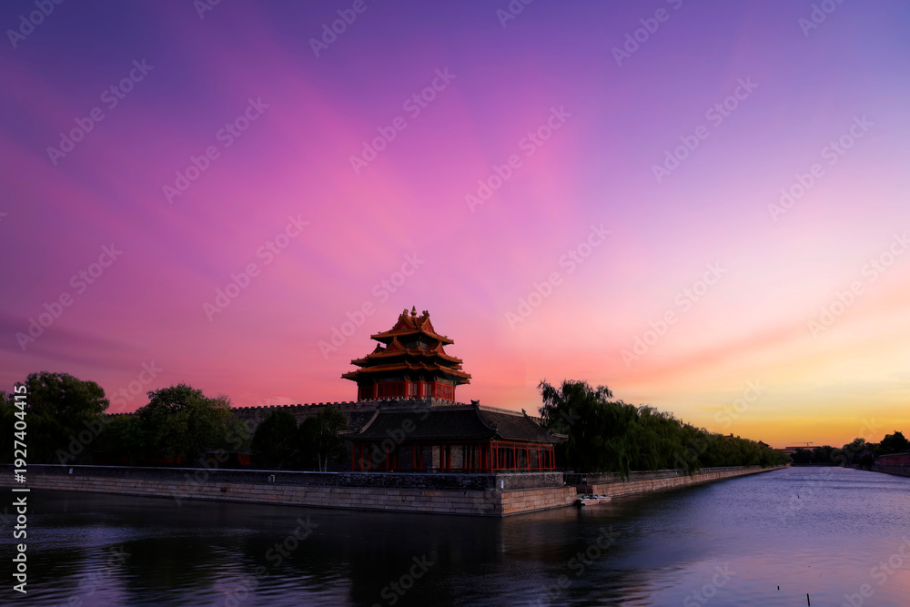 Obraz premium The corner towers of the Forbidden City in China and the beautiful sunset glow at dusk.