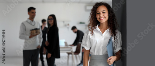 Young African-American woman with clipboard in office