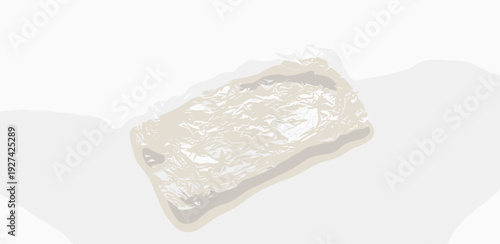 A plastic-wrapped object lies on a plain white surface from a slightly elevated viewpoint