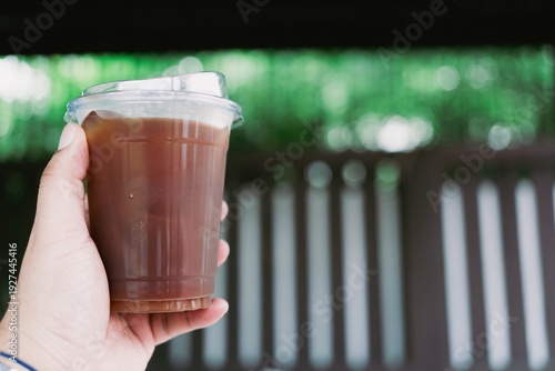 Wallpaper Mural Refreshing iced Americano in takeaway cup in hand Torontodigital.ca