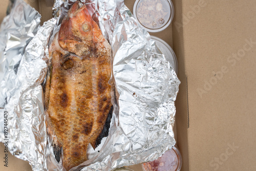 Wallpaper Mural Freshly grilled salt tilapia fish served on foil paper, Thai food Torontodigital.ca