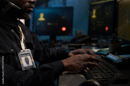 Fotografija Black man working as dispatcher typing on computer keyboard in control room, wea