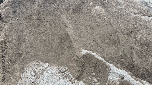 A pile of fine sand as a building construction material with a clearly visible natural texture, suitable to describe the basic material for concrete and plastering work.