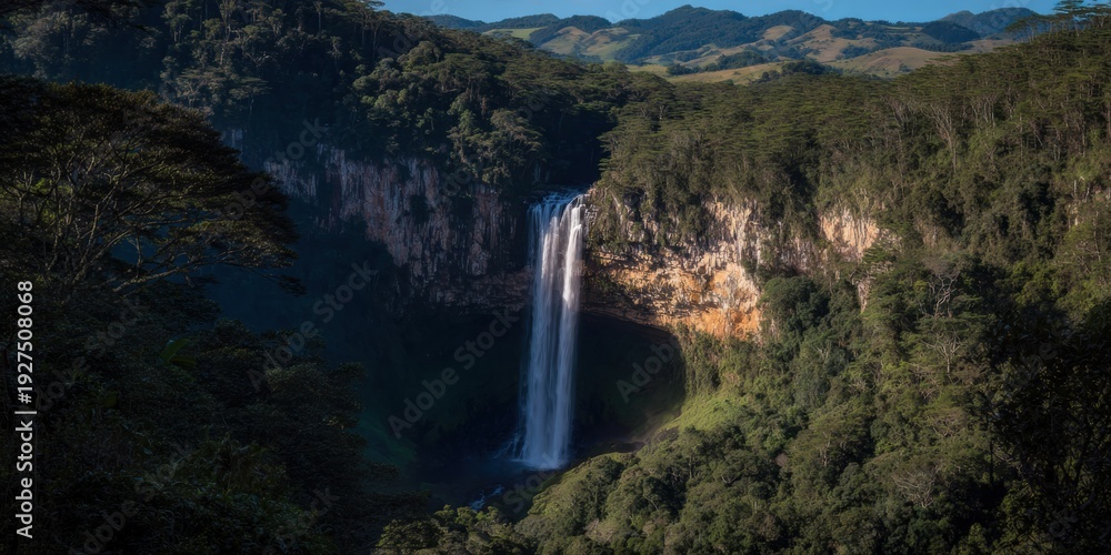 Obraz premium Majestic Waterfall Plunging from a Rocky Cliff Into a Lush Green Rainforest Canyon, Scenic Nature Landscape for Eco Tourism Travel and Wilderness Exploration