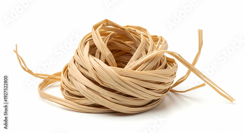 A close-up shot of a neatly coiled ball of natural beige raffia ribbon, isolated on a clean white background.