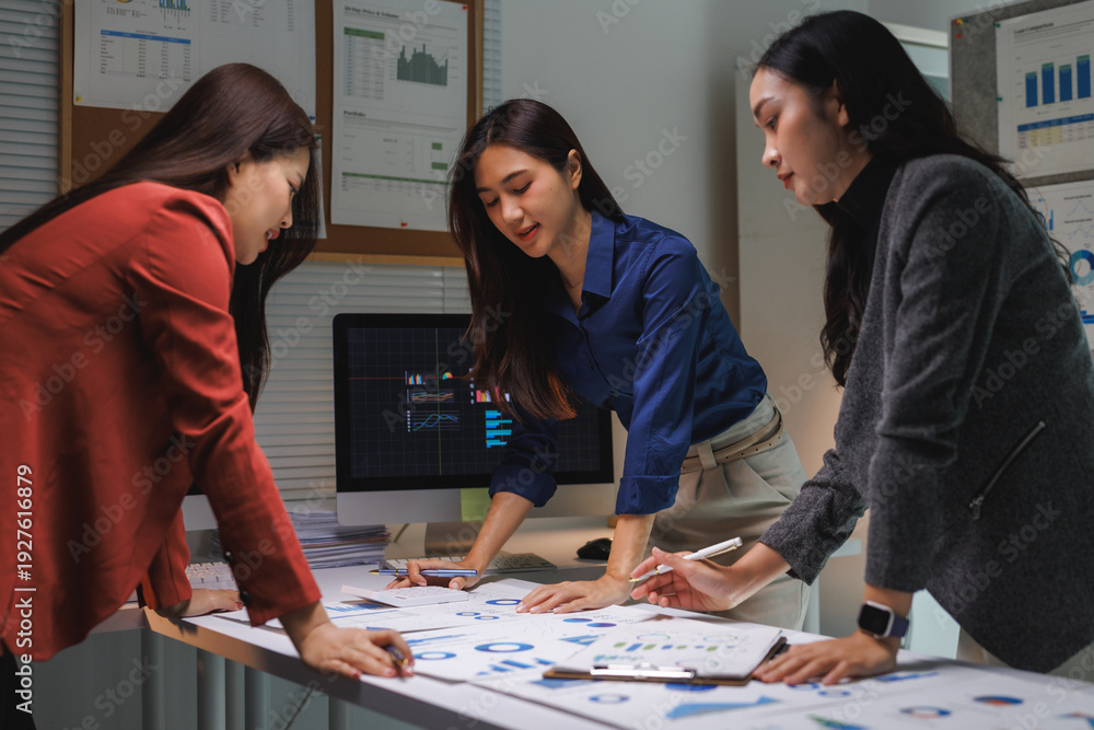 Fototapeta premium Businesswomen analyzing data working late night in office
