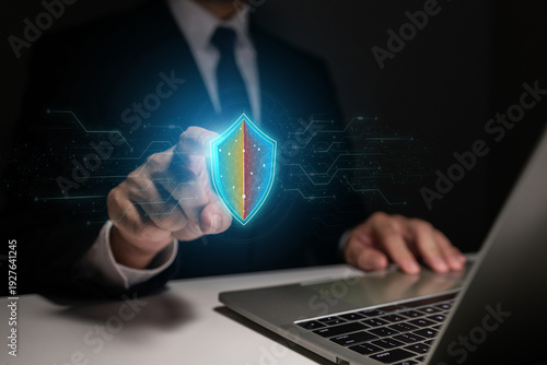 Business professional demonstrating cybersecurity protection concept with virtual shield interface, securing digital assets and preventing online threats.