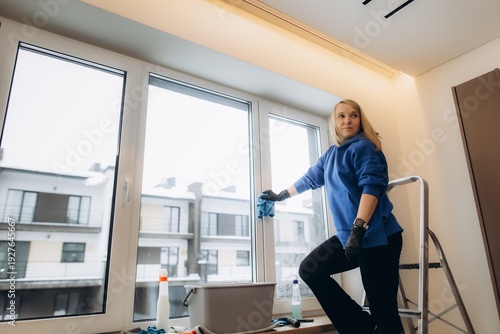 Professional cleaner wiping window during home maintenance