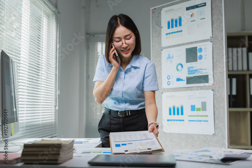 Professional woman communicating on phone reviewing business data