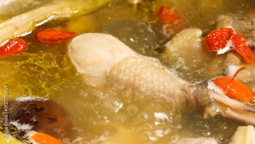 Cuadro en lienzo Close up of simmering herbal chicken soup with red goji berries and mushrooms