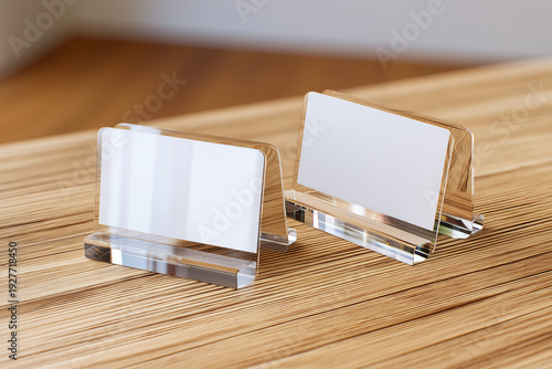 Two pristine acrylic business card displays on a tactile wooden desk