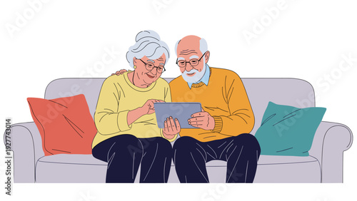 Happy senior couple sitting together on a grey sofa and smiling while looking at a digital tablet together in their living room.