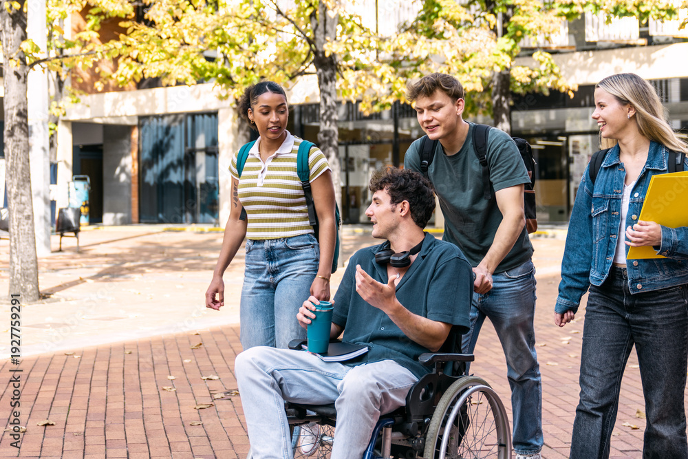 Fototapeta premium College students with a friend in a wheelchair chatting while walking on an inclusive university campus. Friendship and education concepts