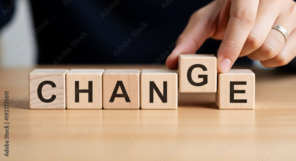 Naklejka premium Hand places wooden block spelling C H A N G E on table change word