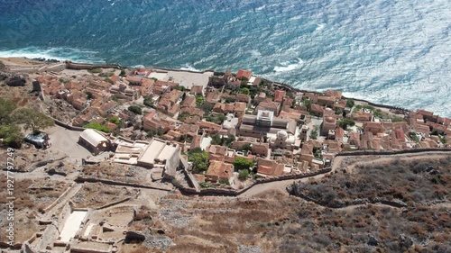 Panoramic view of medieval Monemvasia ruins above rough sea coastline Greece