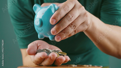 Saving coins in a piggy bank, financial planning, and investing for the future for financial growth.