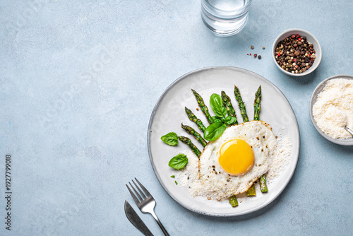 Fried egg with green asparagus and grated parmesan cheese for healthy breakfast