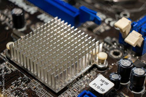 Close-up of part of an electronic circuit board with electronic components and a large chip and heat sink