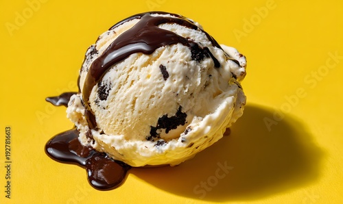 a single scoop of cookies and cream ice cream on a bright yellow surface