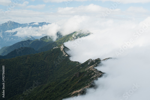 Travel to the high mountain peak where fog and mist drift across the landscape, painting the sky with silver light and turning the quiet scenery into radiant sunrise sky.