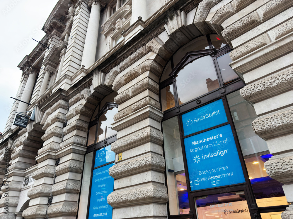 Naklejka premium Manchester street scene with grand stone building housing Smile Stylist Dental Clinics and Invisalign signage