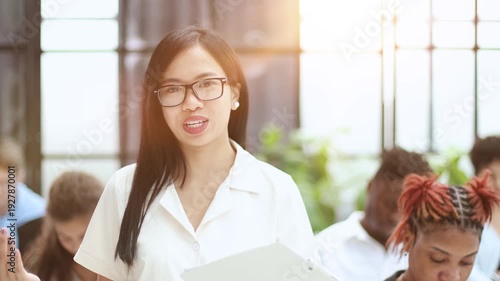 Business woman talking in a conference room against the background of students