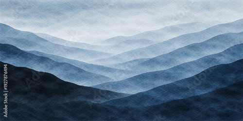 A wide winter landscape of snow covered mountains under a blue sky and clouds with a misty morning fog rising over the cold