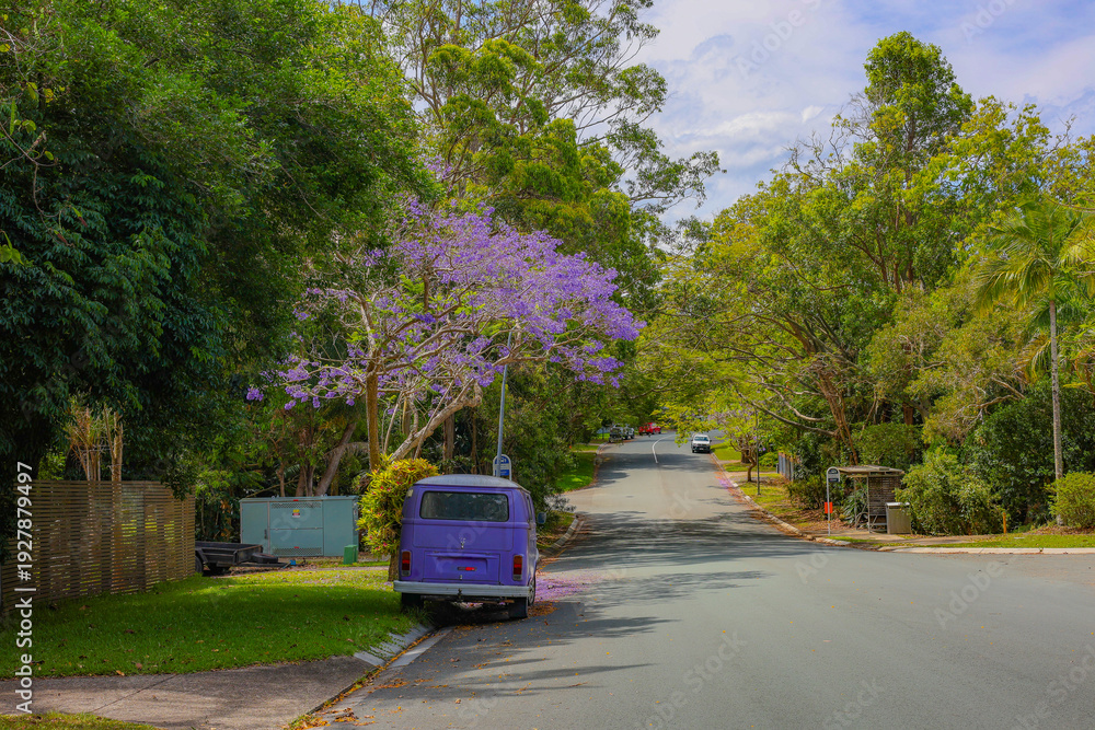 Obraz premium A purple van under a tree, purple flowers, in spring.