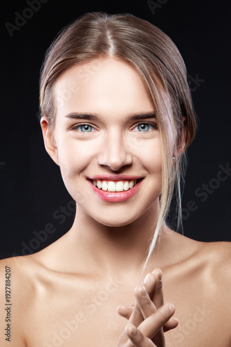 Beautiful Blonde Woman Portrait with healthy Hair.Clear Fresh Skin. Smiling Girl Isolated on a Dark Background. Skincare. Spa.Beauty Model