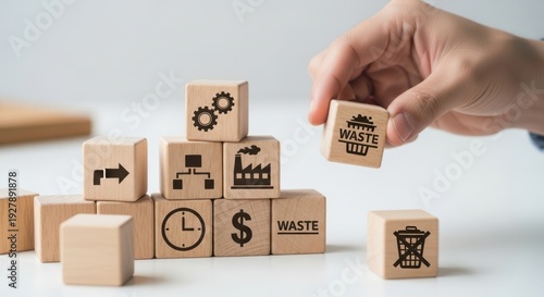 Lean manufacturing principles and removing unnecessary cubes from the layout using wooden cubes, symbolic icons, human hand, natural depth of field, soft blurred background, minimal desk background.