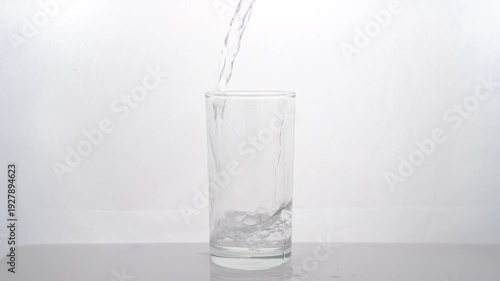 Slow-motion video of clean water being poured into a glass on white background healthy drink.	