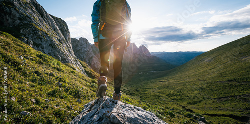 Woman backpacker hiking on sunset alpine mountain top