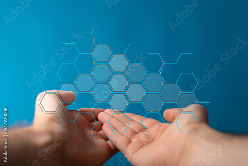 Abstract image of hands supporting a digital hexagon network representing technology, innovation, and connection on blue