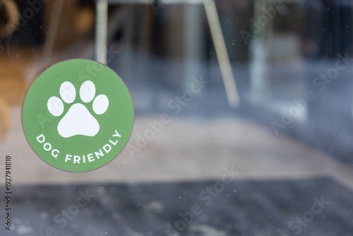 Dog friendly sign on glass door, close up sticker with copy space in natural daylight