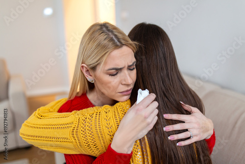 Фотография Sad blonde woman crying and hugging her friend
